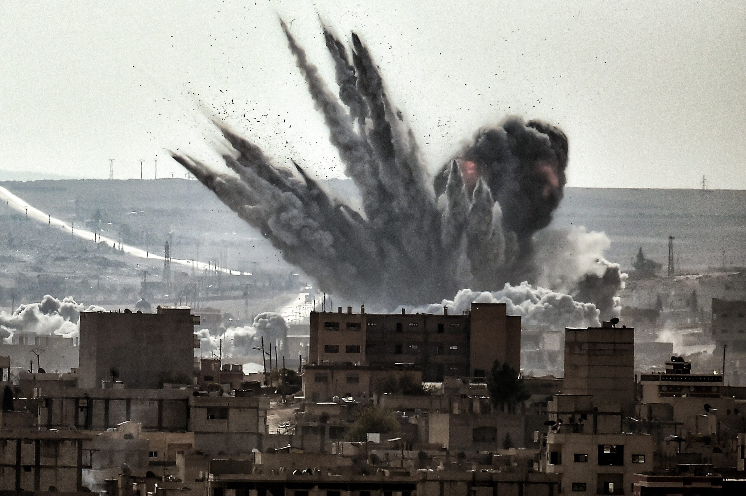 A shell explodes on November 13, 2014 in the Syrian city of Kobane, also known as Ain al-Arab, as seen from the Turkish border village of Mursitpinar, Sanliurfa province. A report issued on November 13 by the Norwegian Refugee Council and International Rescue Committee says Syrians are increasingly unable to escape their country's war as tougher policies in potential host nations are preventing them from taking refuge in the region and beyond. AFP PHOTO / ARIS MESSINIS / AFP PHOTO / ARIS MESSINIS
