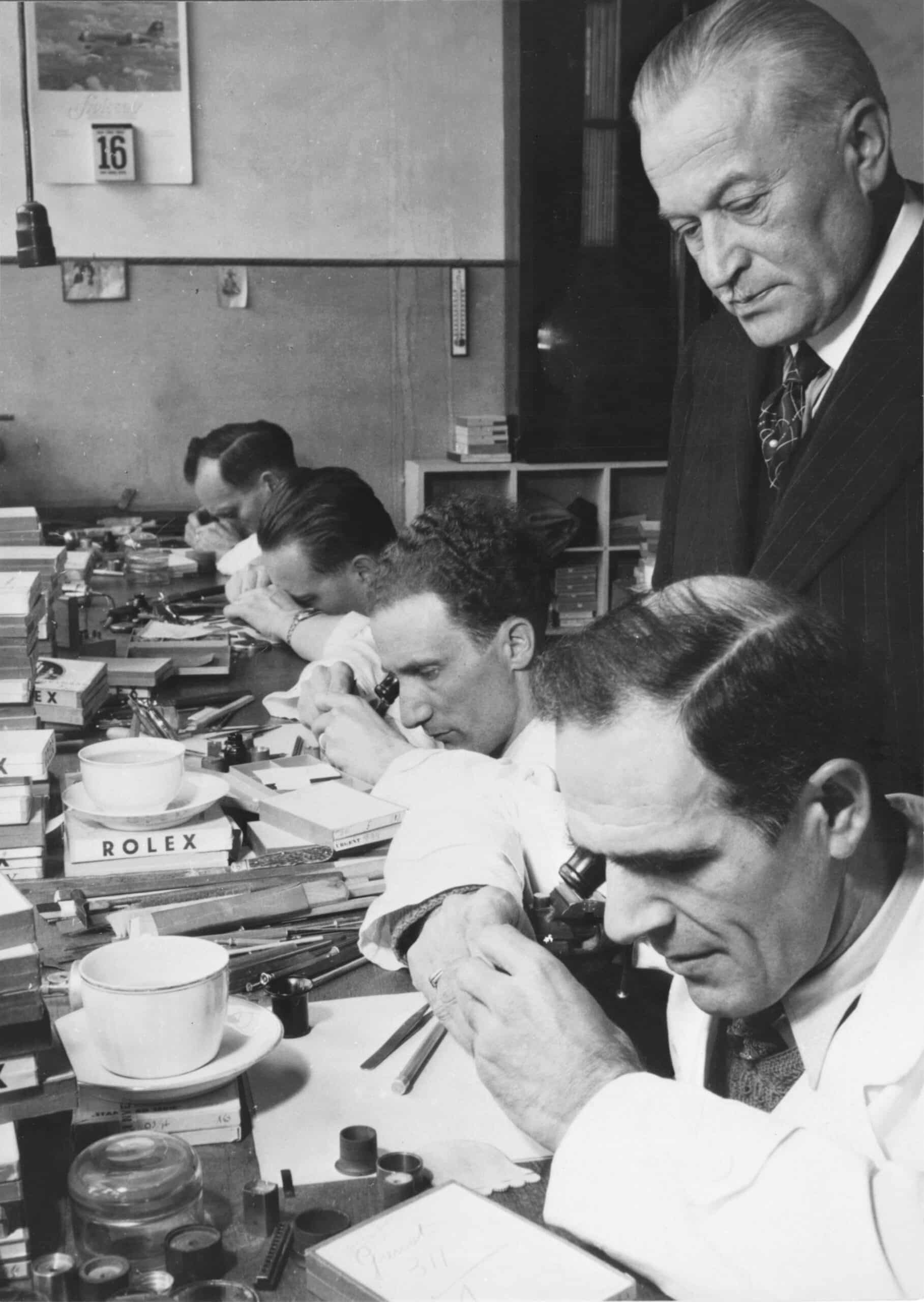 Hans Wilsdorf into Rolex workshops at the rue du Marché with watchmakers at work.
Hans Wilsdorf dans les ateliers Rolex de la rue du Marché avec les horlogers au travail.