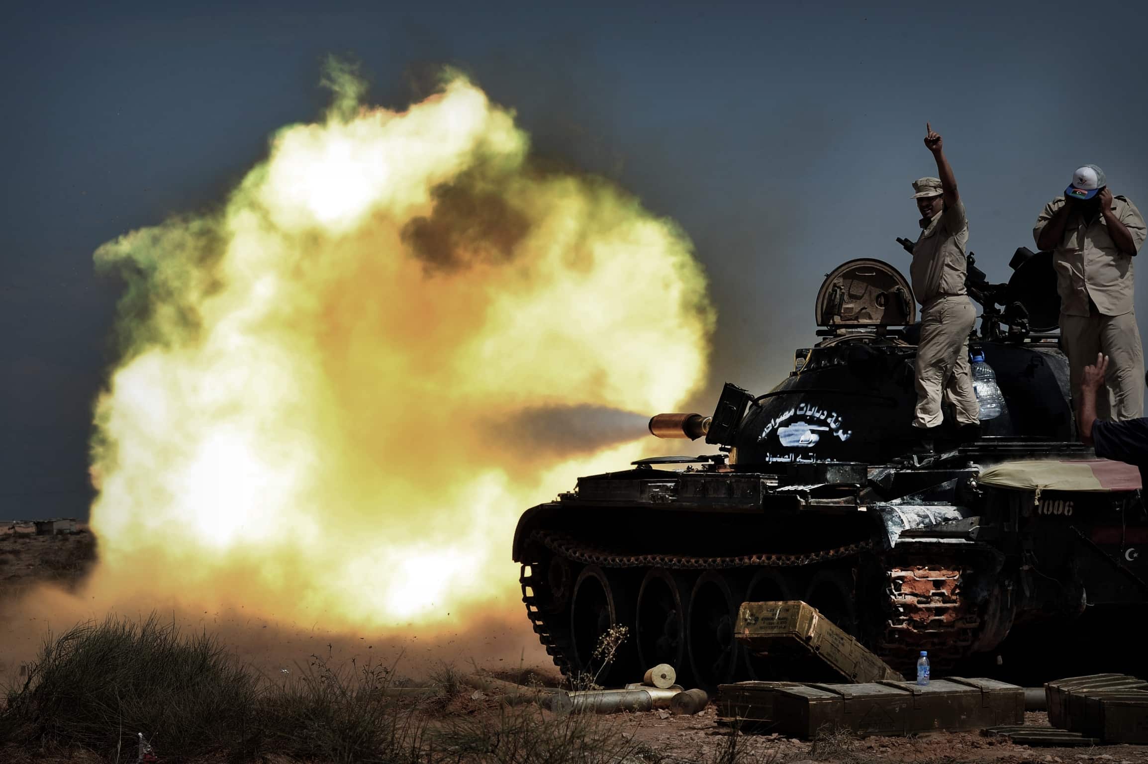 A National Transitional Council fighters fire with a tank against troops loyal to Moamer Kadhafi in the town of Sirte on October 04, 2011. AFP PHOTO / ARIS MESSINIS